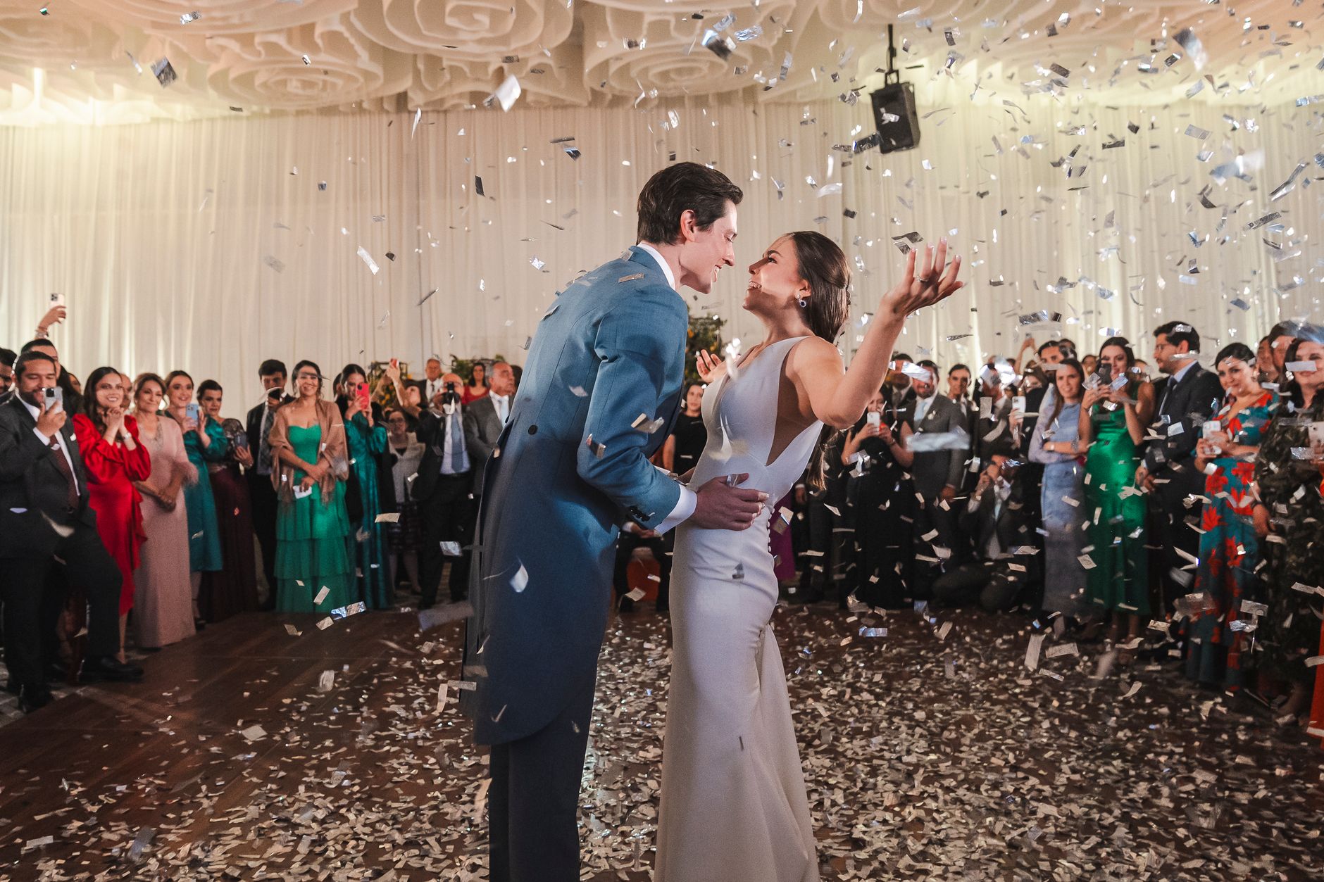 Bride and groom celebrate with confetti at a vibrant wedding in Mexico.