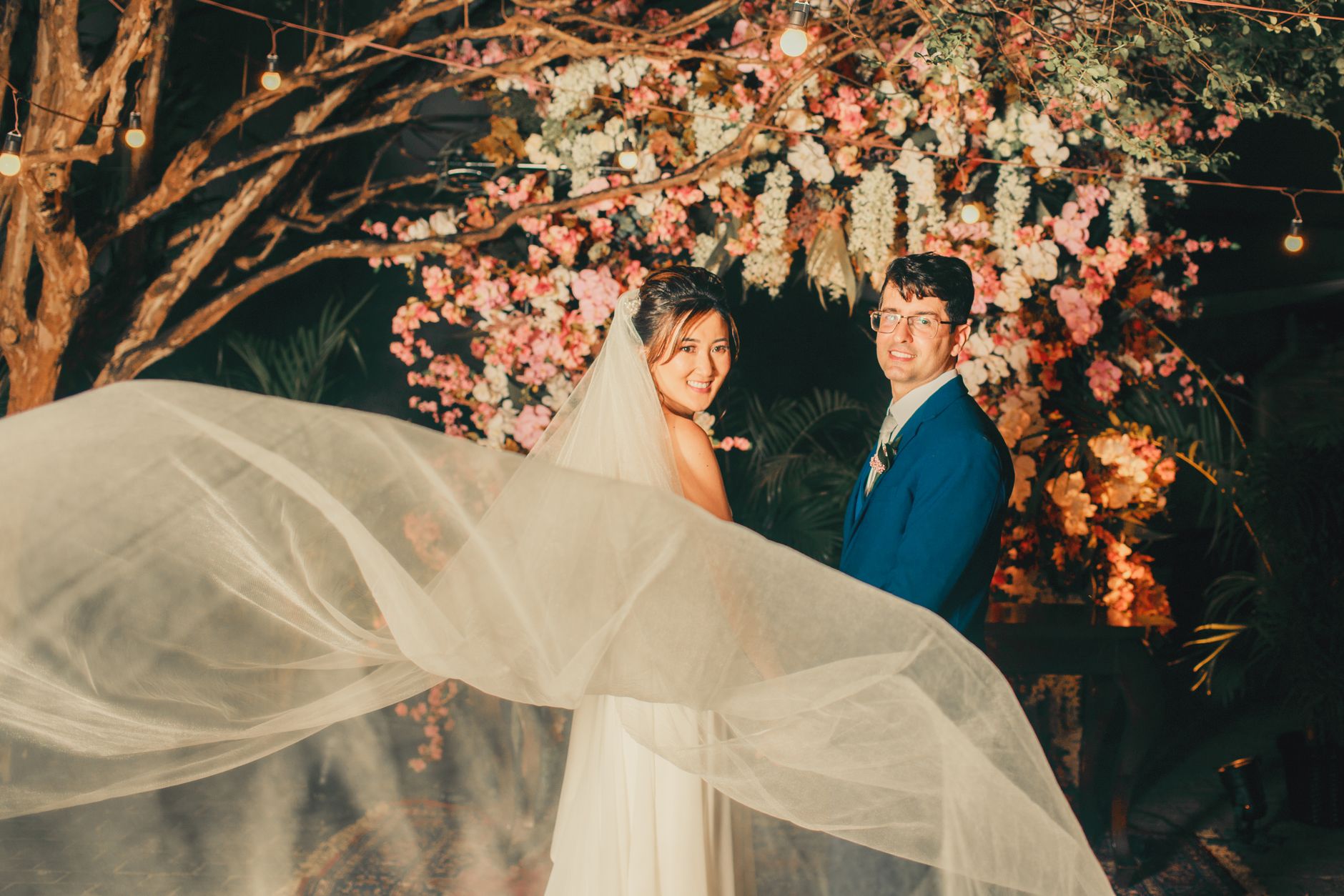 Beautiful couple enjoys their wedding day with stunning floral decorations and romantic lighting.