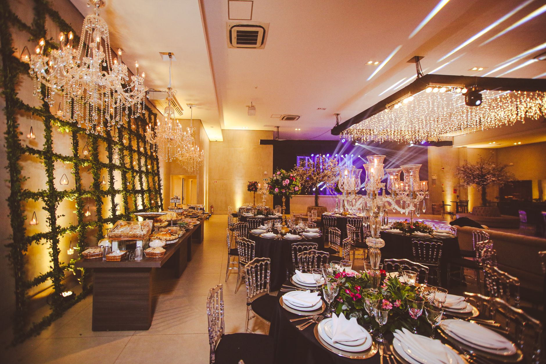 Luxurious banquet hall setup with elegant chandeliers and floral decorations for a special event.